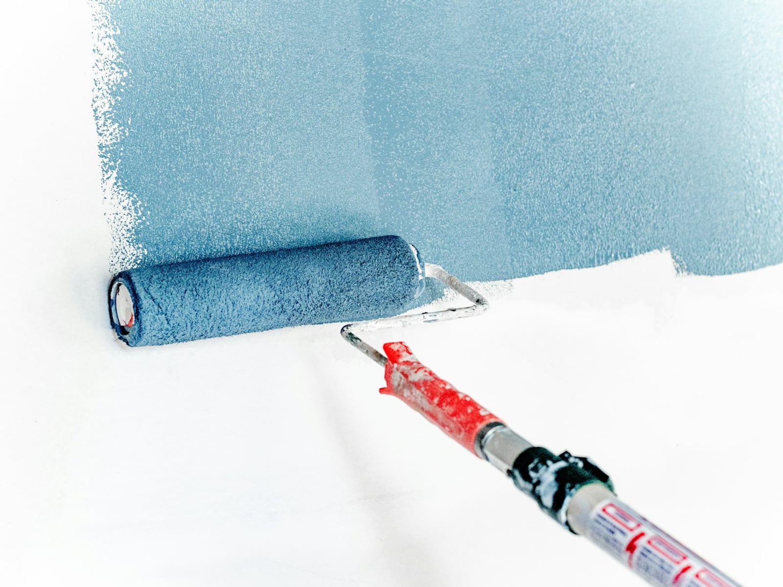 Paint roller applying a clean coat — careful finish work.